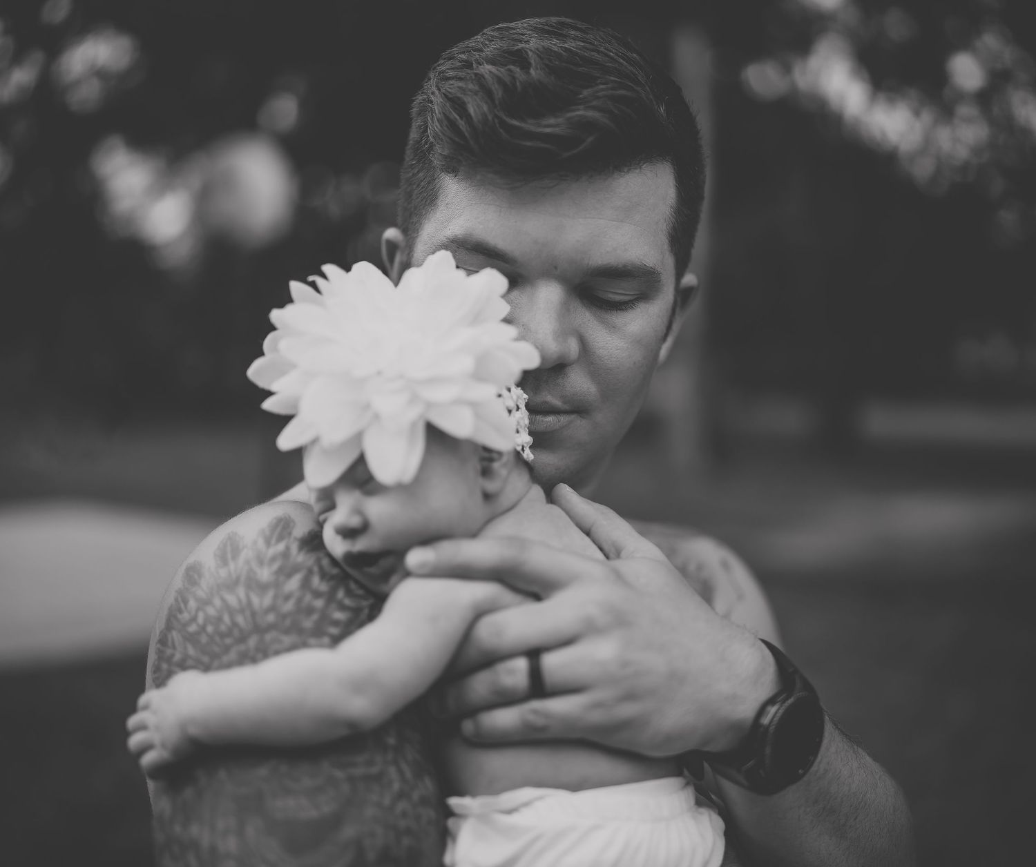 Black and white photo showing a tender moment with a white flower accessory.