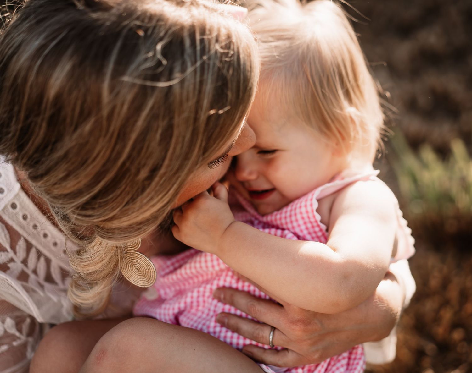 Intimate moment captured between parent and child during outdoor photo session.