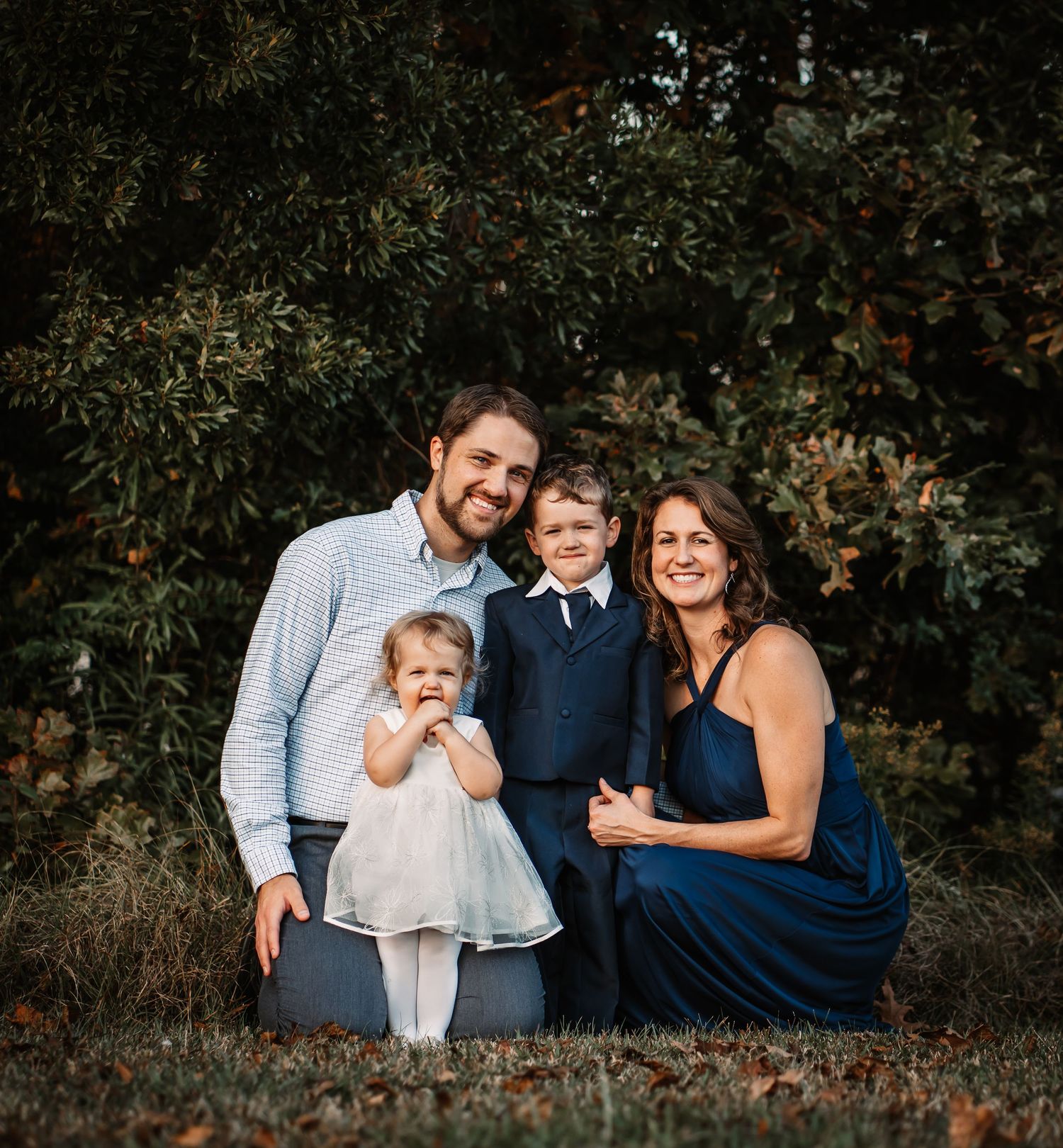 Elegant family portrait in navy and white against autumn foliage.