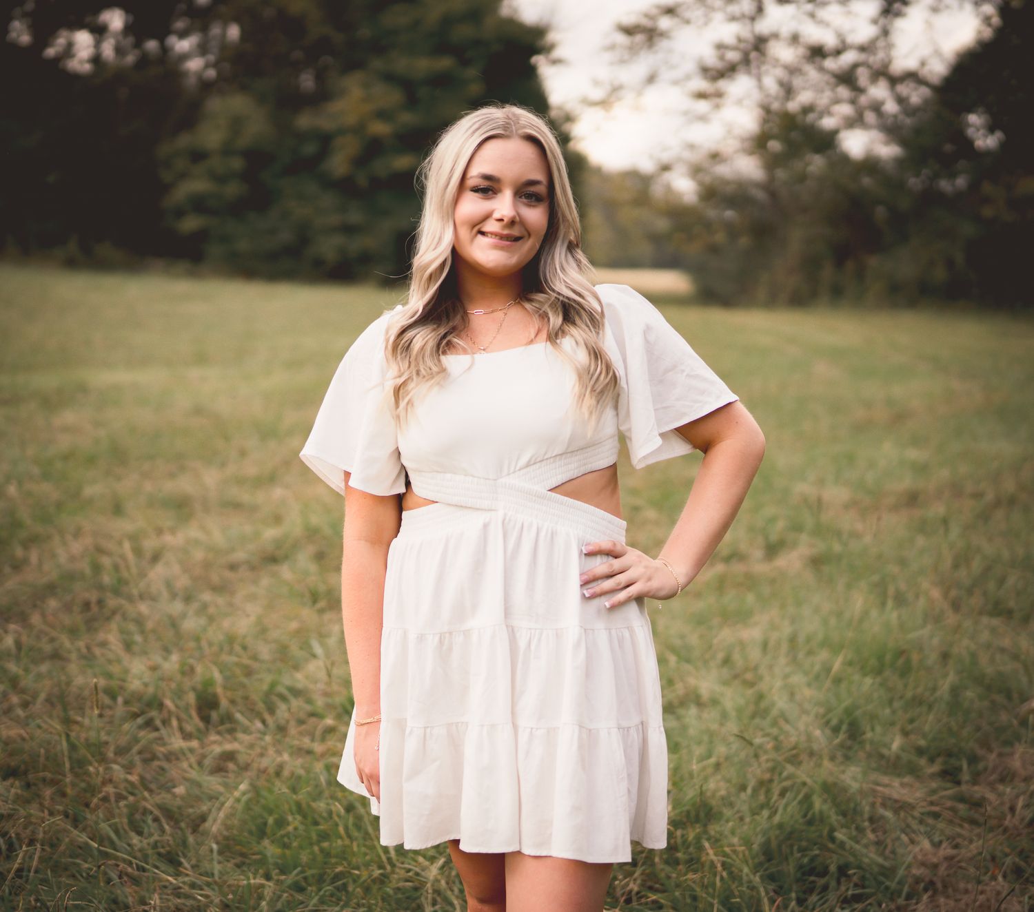 A collection of lifestyle portraits in a grassy field featuring white summer clothing and natural poses.