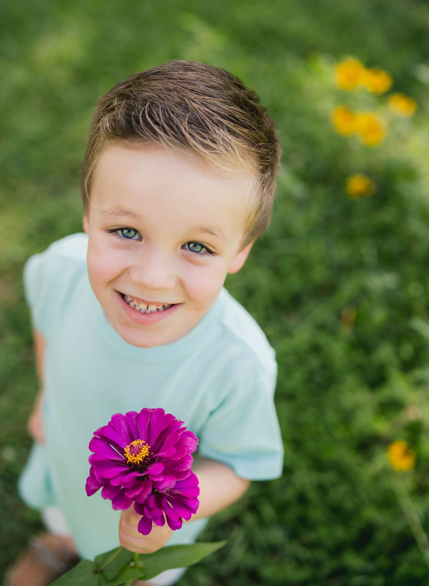 Close-up outdoor portrait with a vibrant purple zinnia flower against a green garden background.