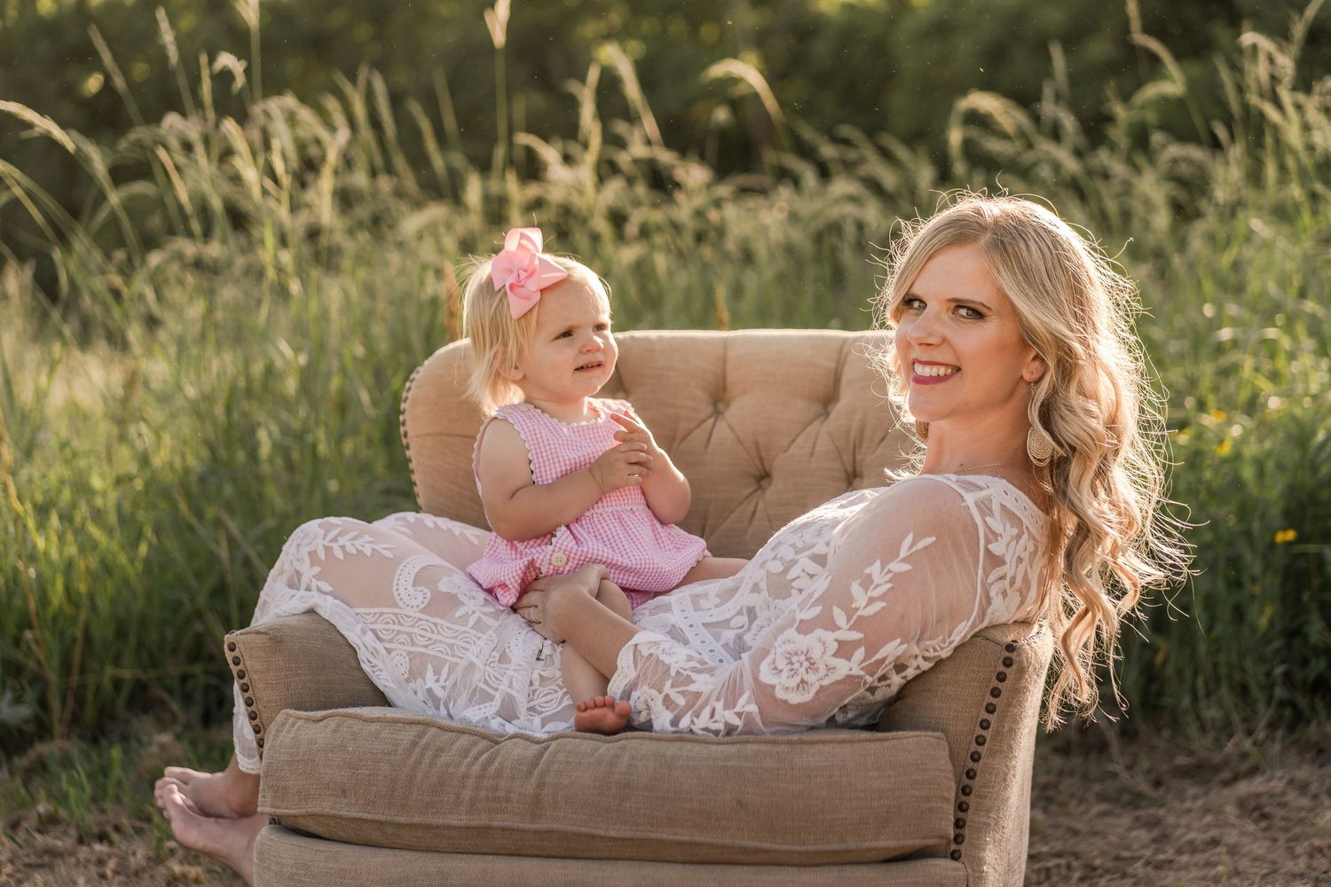 Candid moment on vintage sofa in golden wheat field during sunset photo session.
