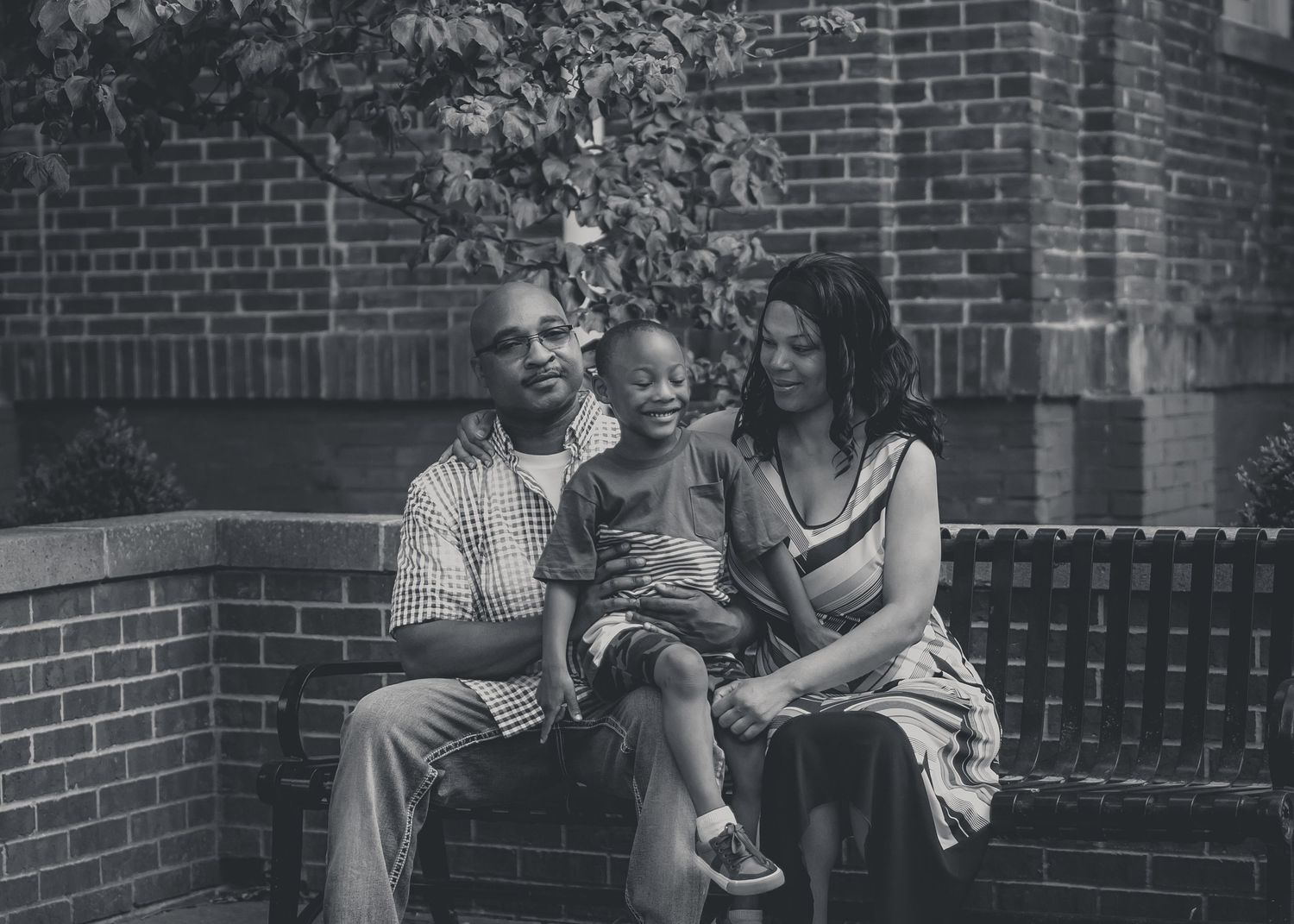 People sitting and relaxing together on a porch with brick walls in a black and white photograph.