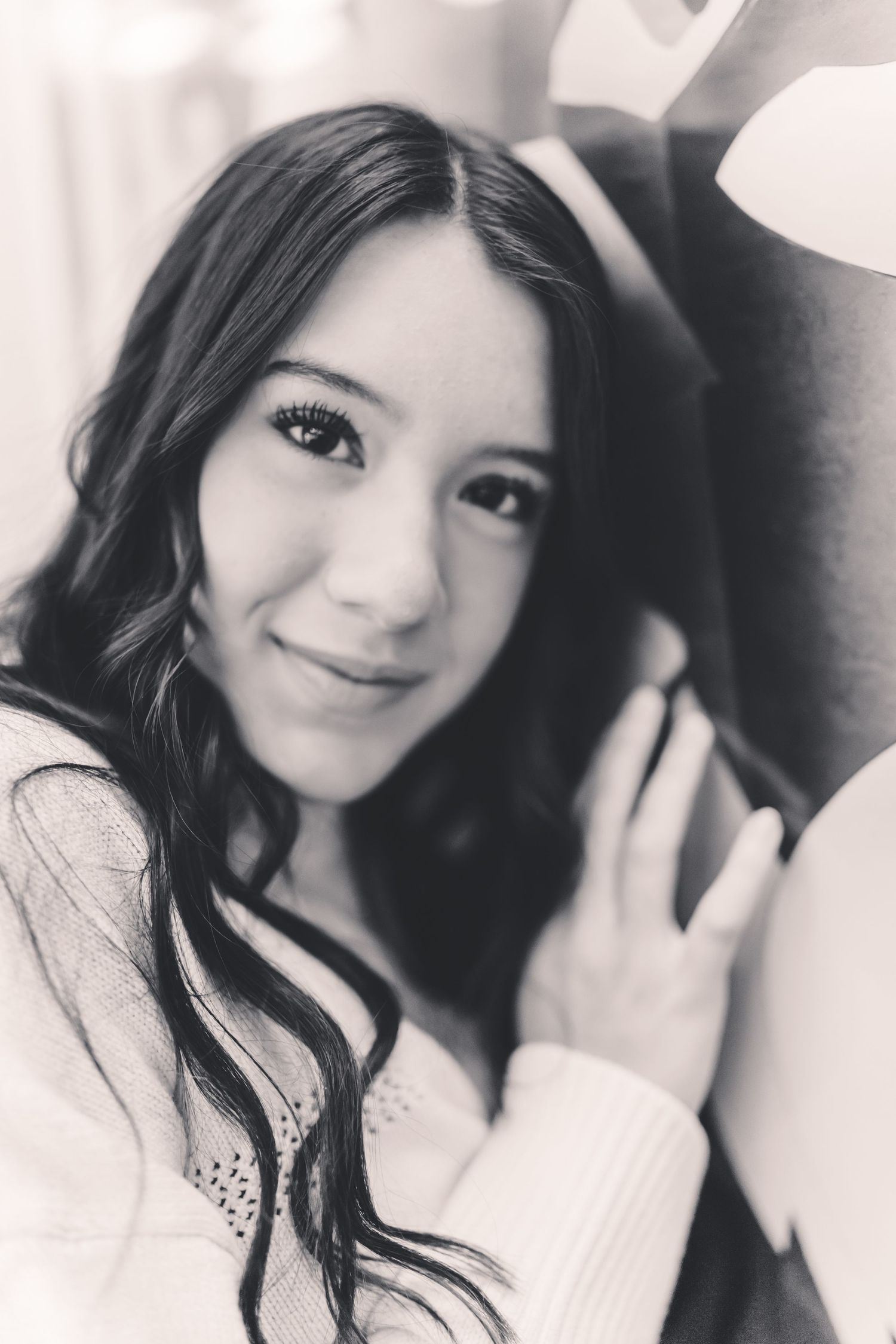 A series of black and white selfie portraits showing a young woman in a light colored top with long dark hair.