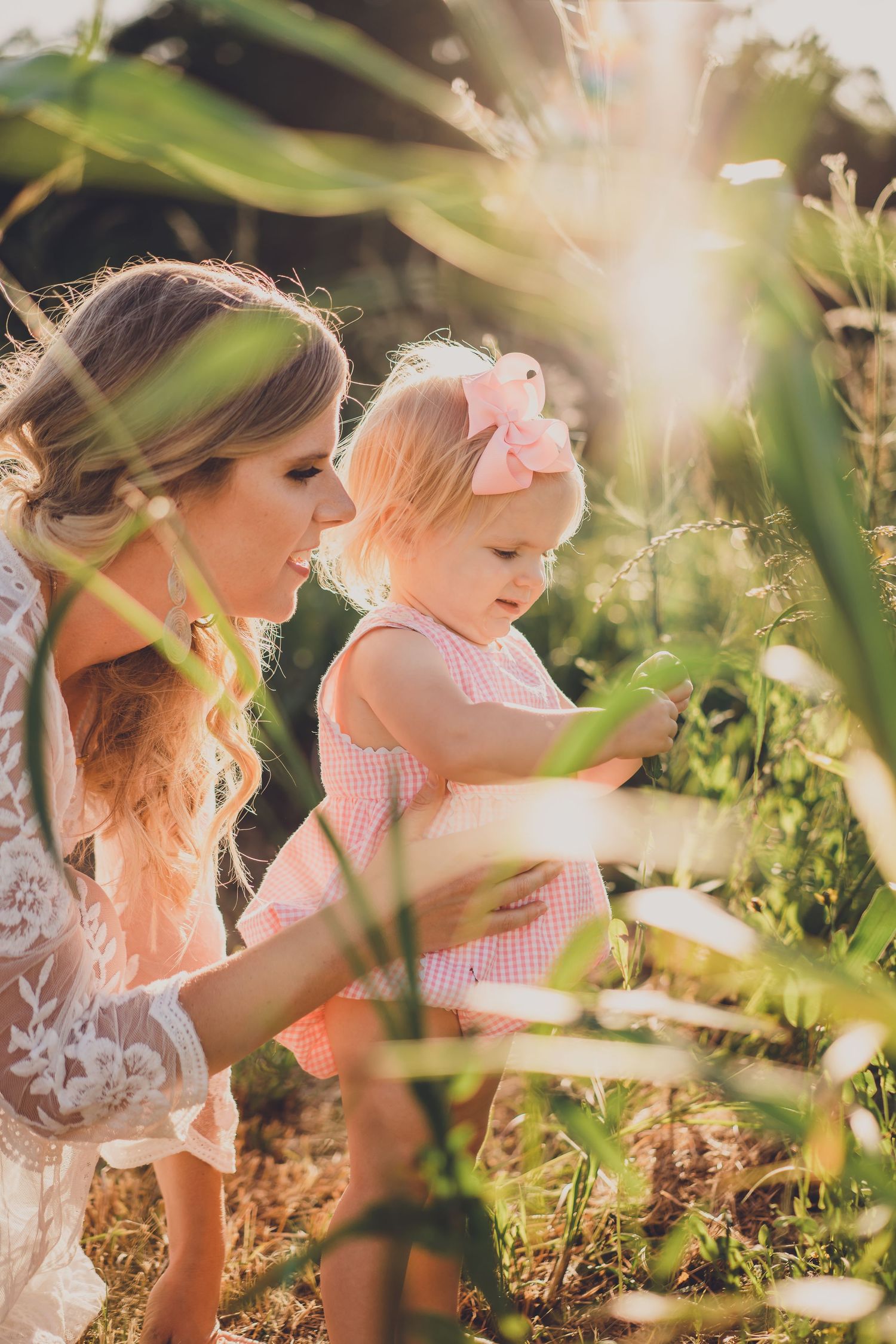 Sun-drenched garden photo of parent and child exploring nature together.