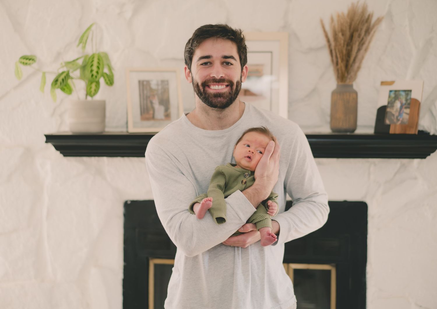 A series of four black and white photos showing tender moments between parent and child in a bright interior space.