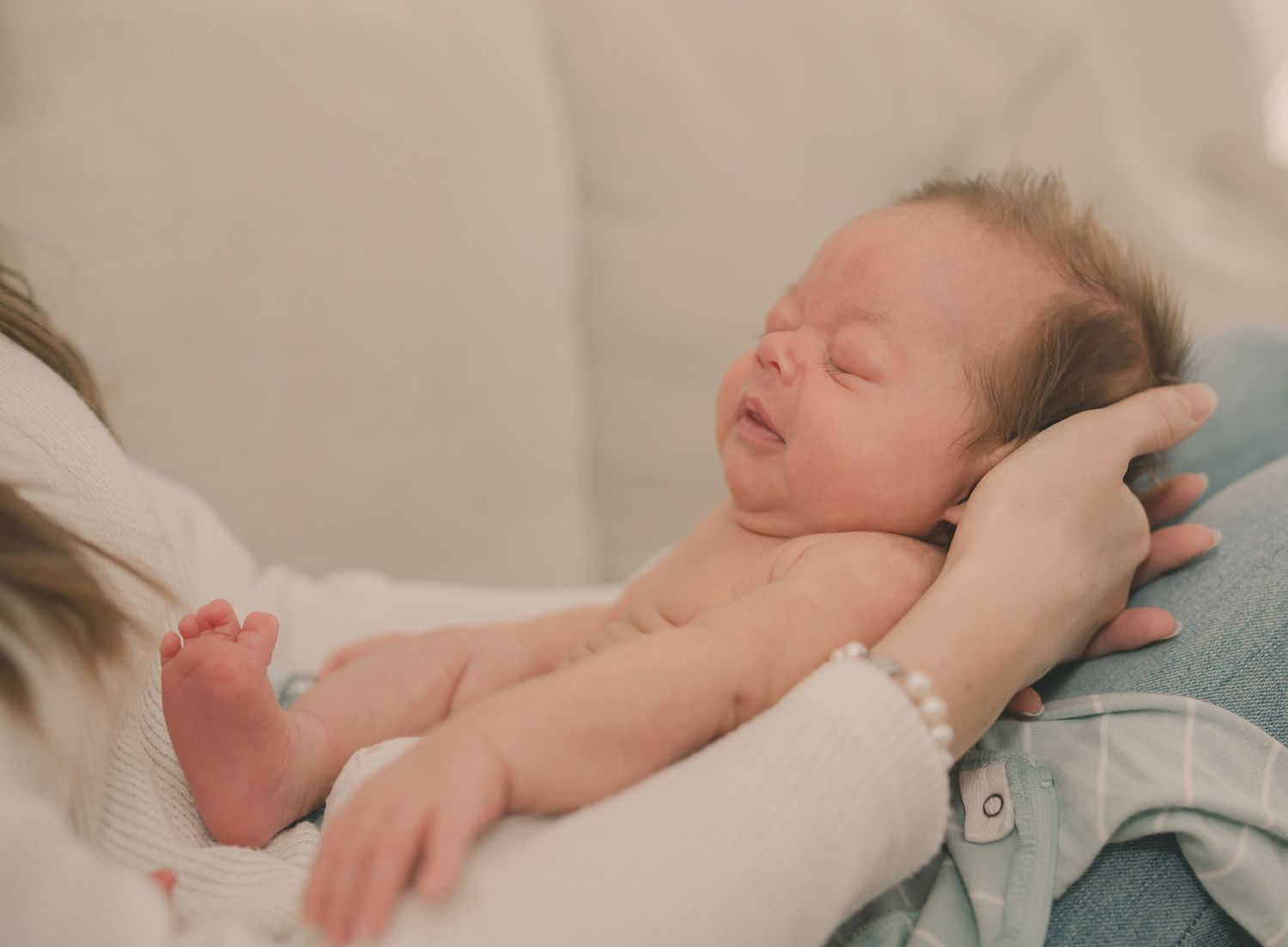 A sleeping baby lies peacefully on soft white bedding in a series of connected images showing different resting positions.