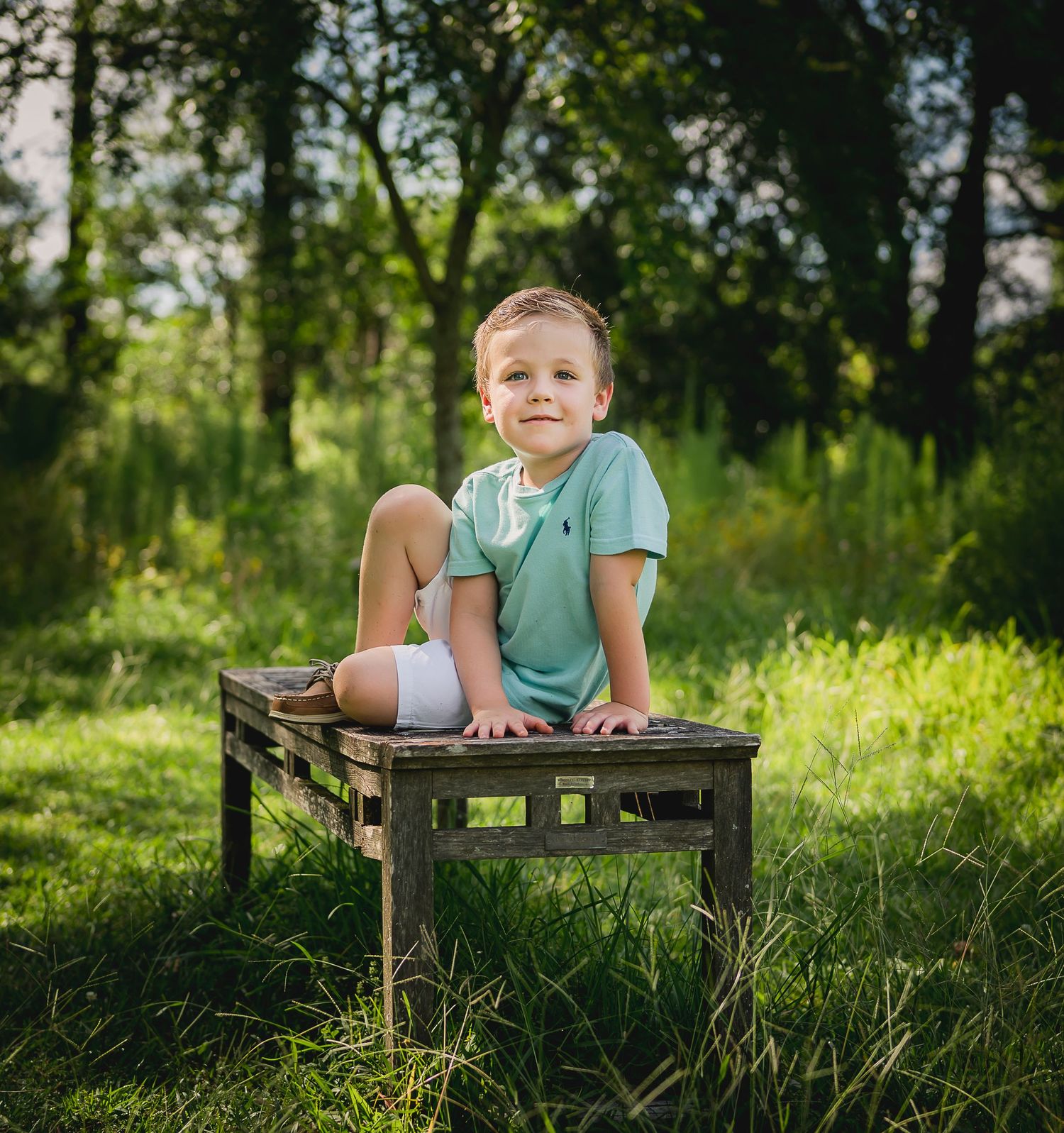 A playful portrait in a lush garden setting showing a small figure perched on a rustic wooden table.