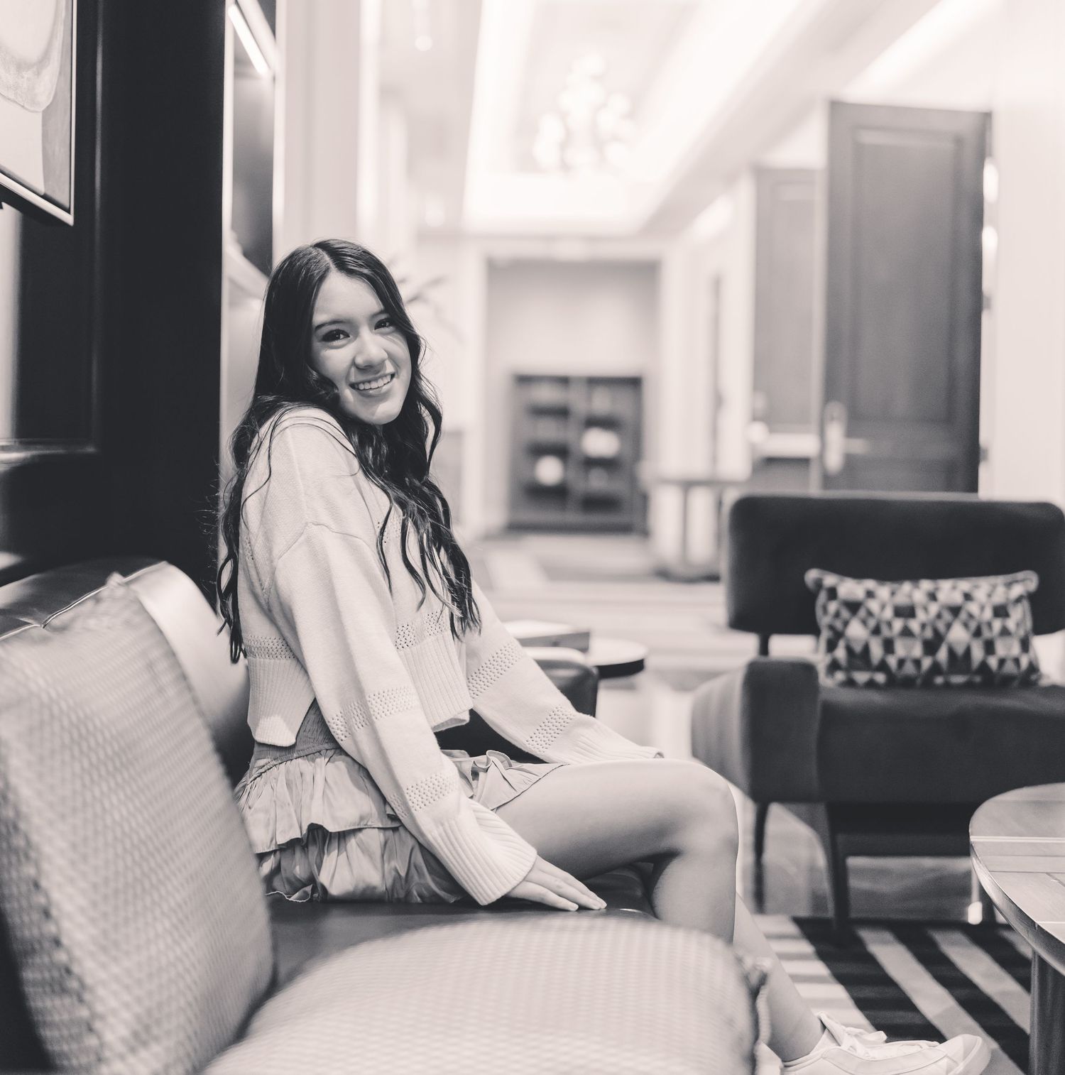 Black and white photo of someone relaxing on a couch in a casual indoor setting.