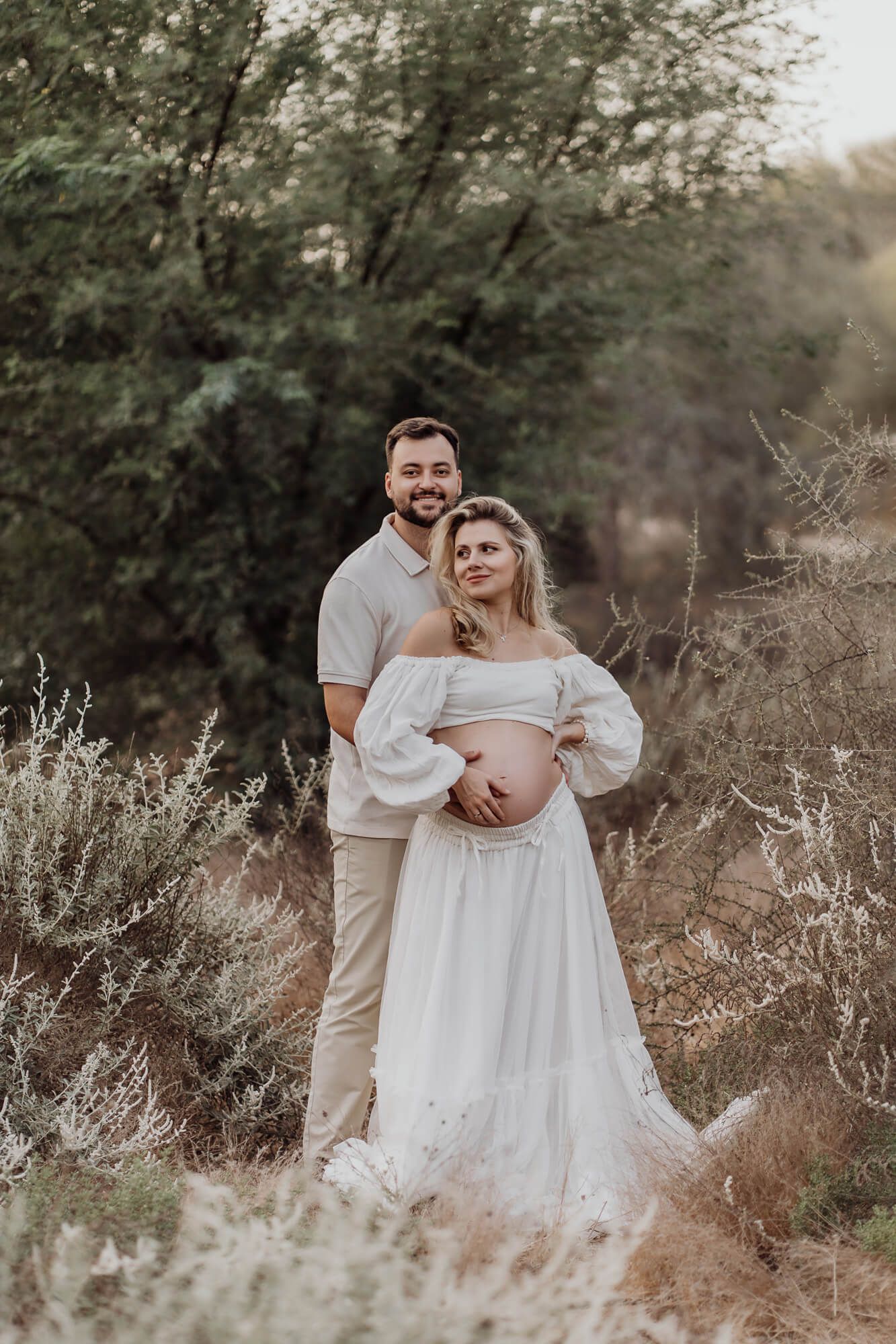 Artistic maternity photos taken at golden hour in a natural outdoor setting.