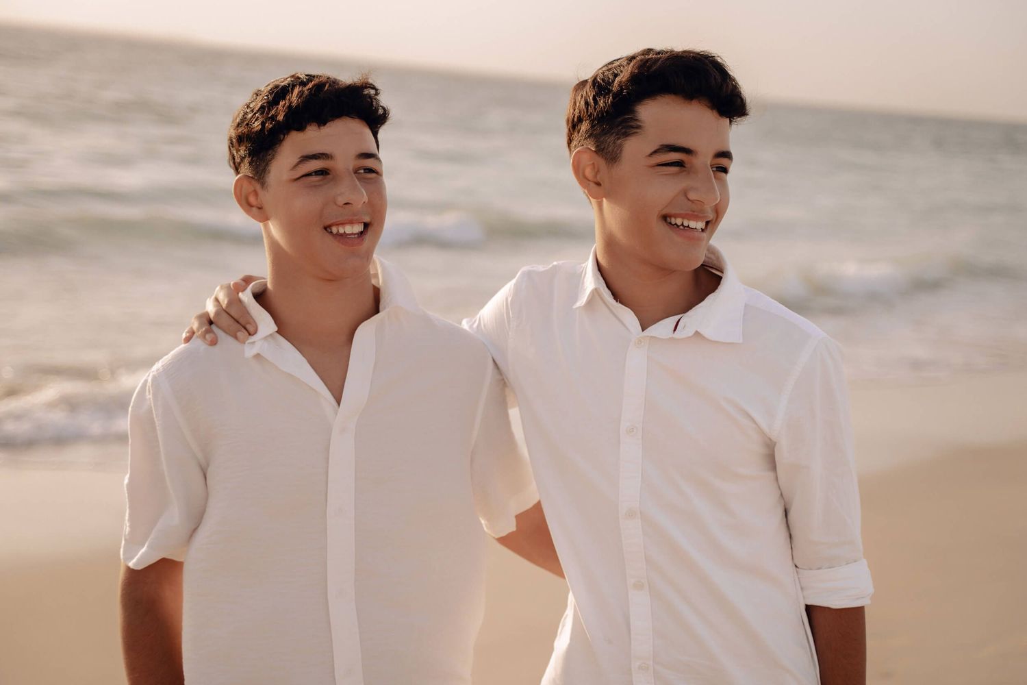 Casual beach portraits showing genuine smiles and laughter at golden hour.