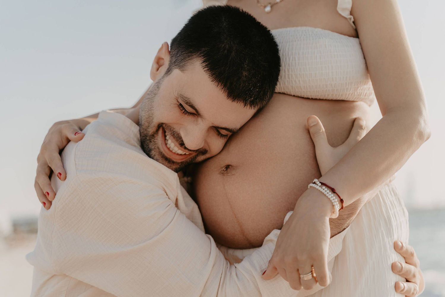 A collage of intimate maternity photos showing a pregnant belly and tender embrace.
