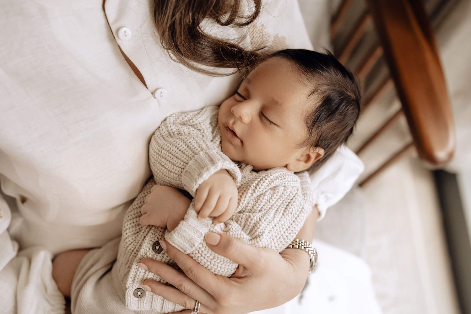 Collage of peaceful newborn baby portraits in soft neutral tones with gentle lighting and white blankets.