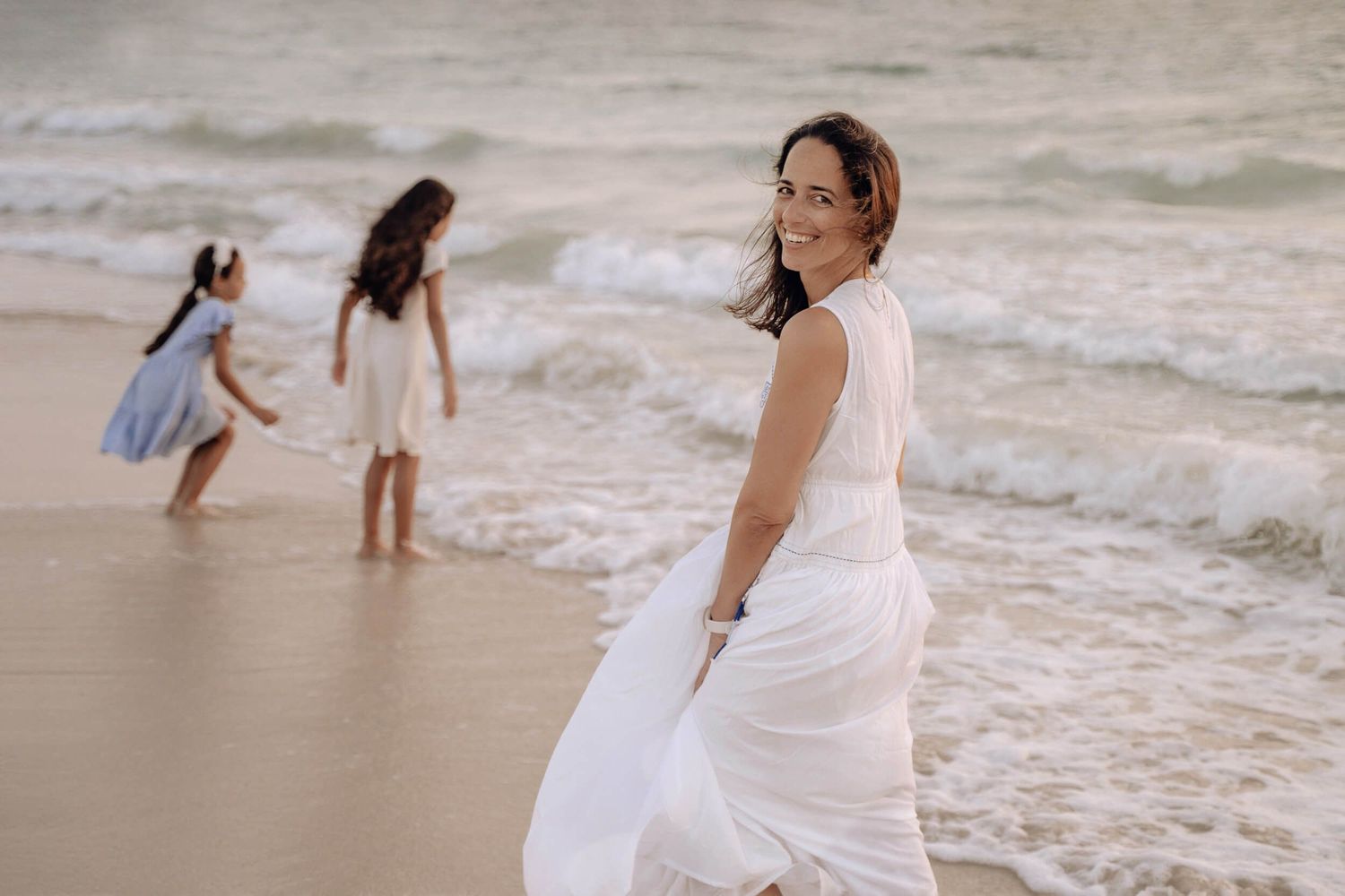 Joyful couple plays and dances together at the edge of the ocean waves.