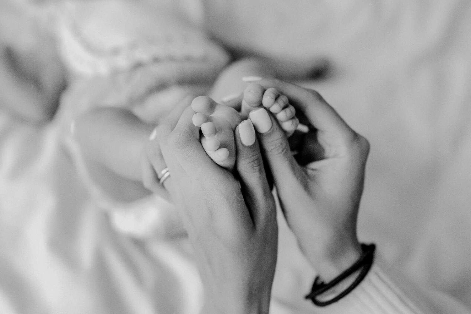 Black and white image of tiny newborn feet with delicate details.