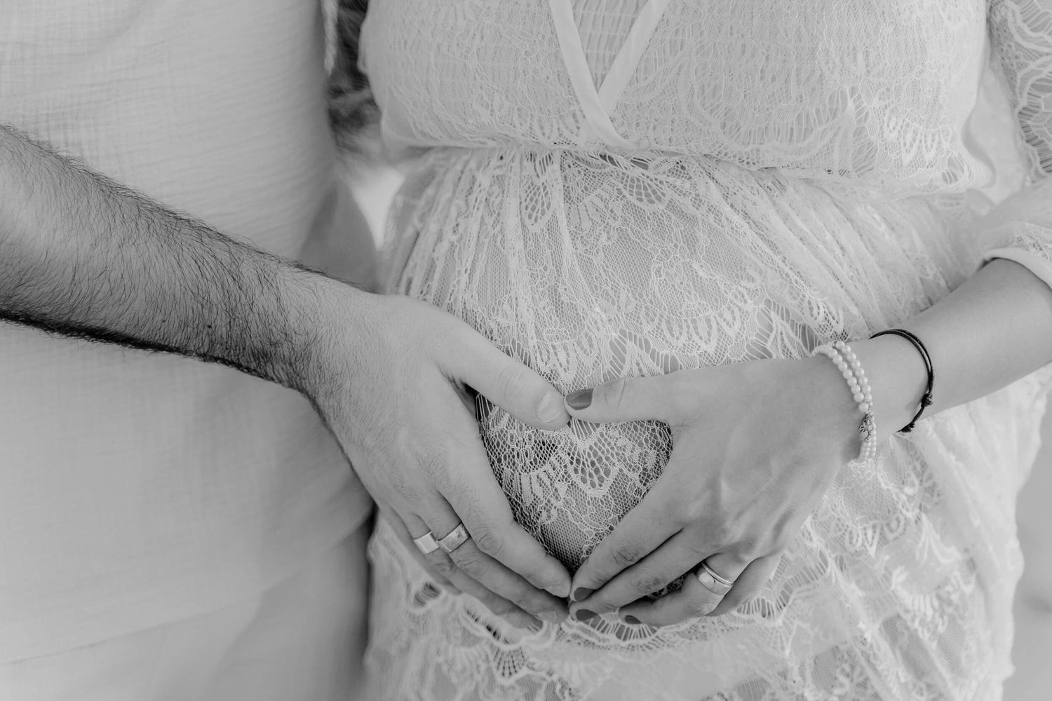 A delicate detail view of intricate white lace fabric decorating wedding attire.