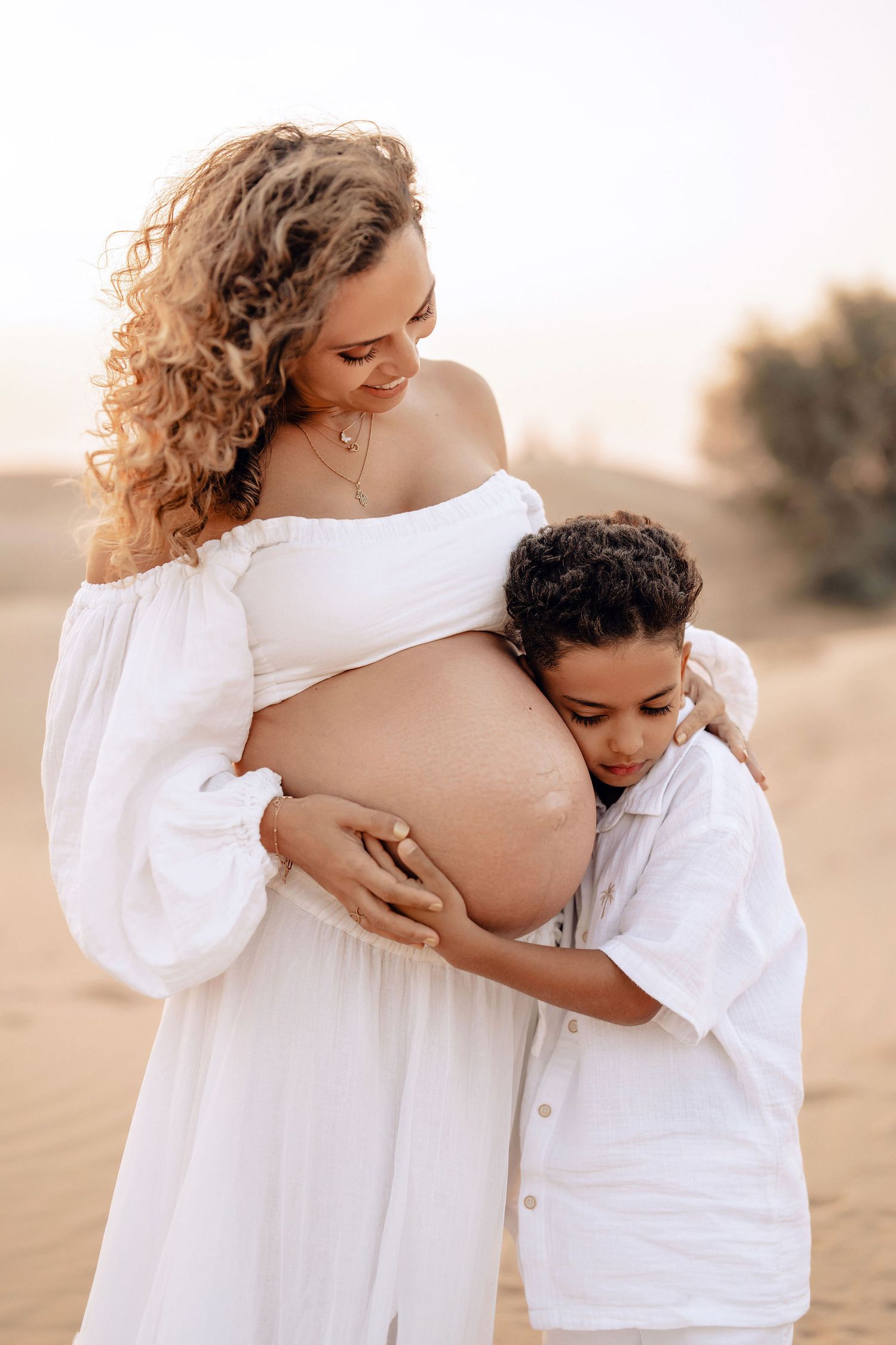 Pregnant mother in a flowing dress during a desert maternity session in Dubai