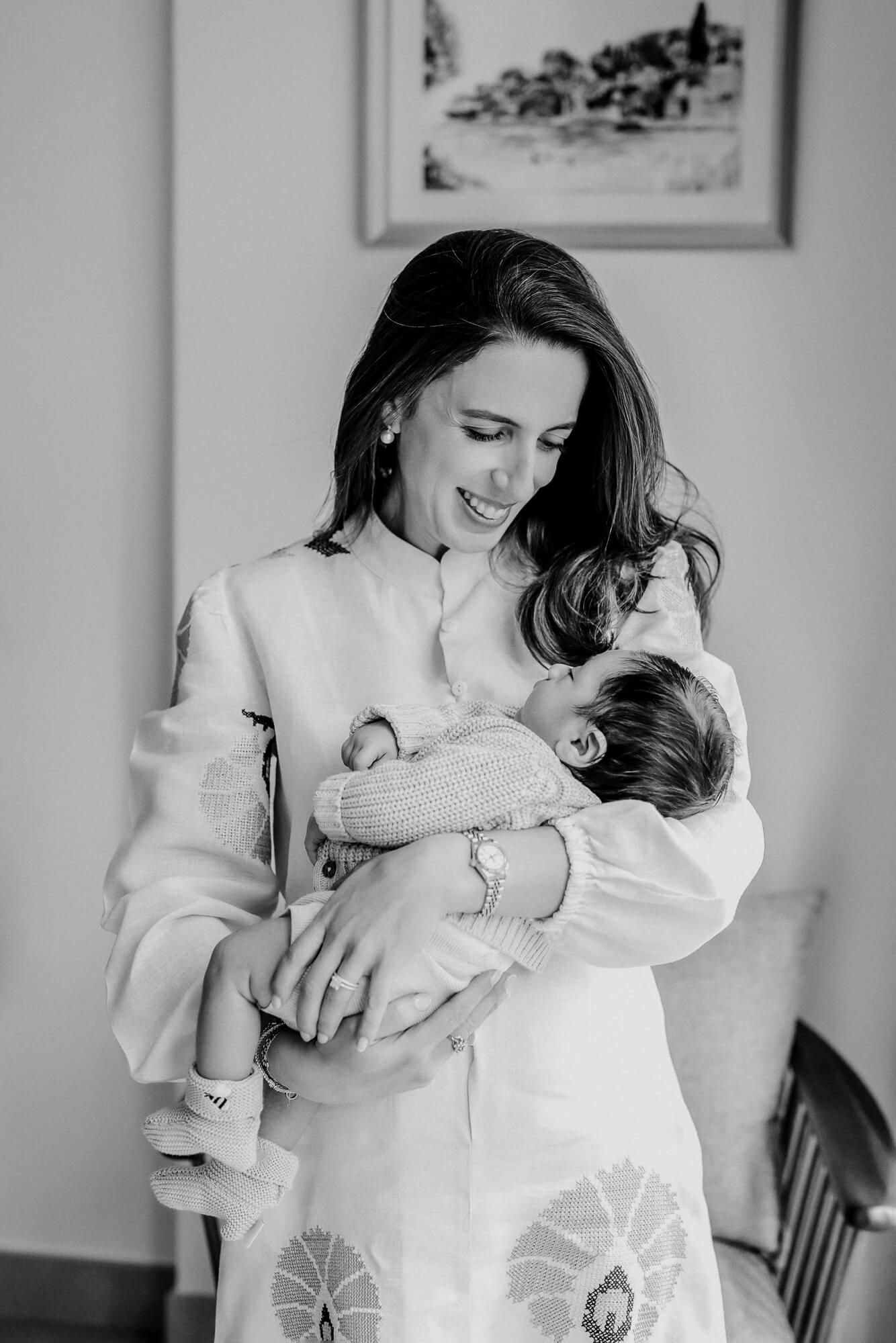 Black and white photo of tender snuggling between parent and infant.