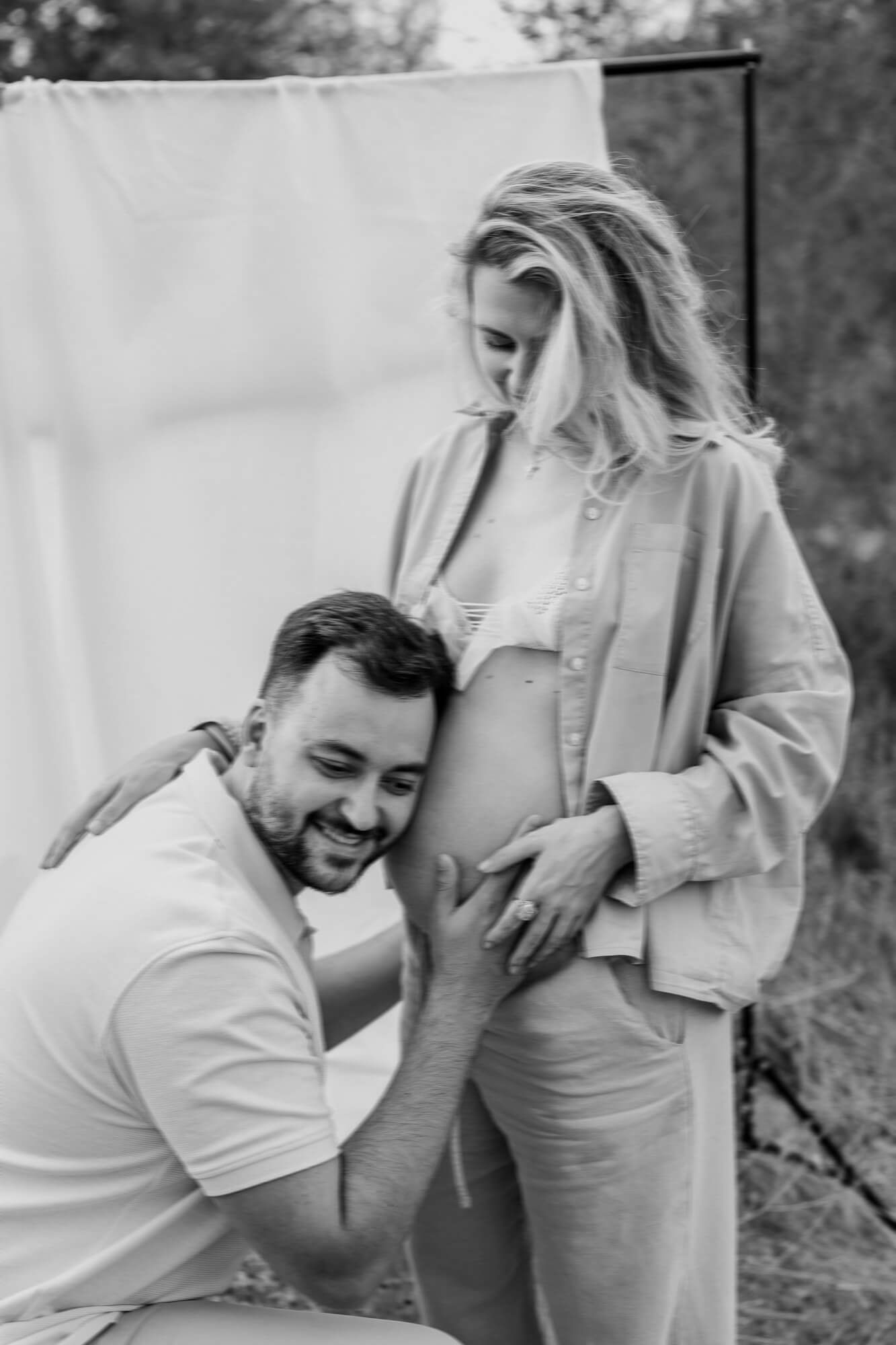 Black and white pregnancy photo capturing an intimate moment with the baby bump.