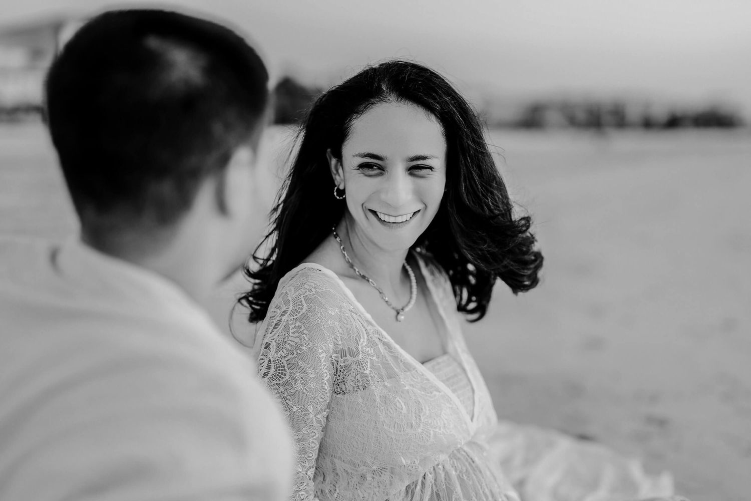 A black and white wedding series showing a bride outdoors in a lace dress with joy and laughter during her special day.