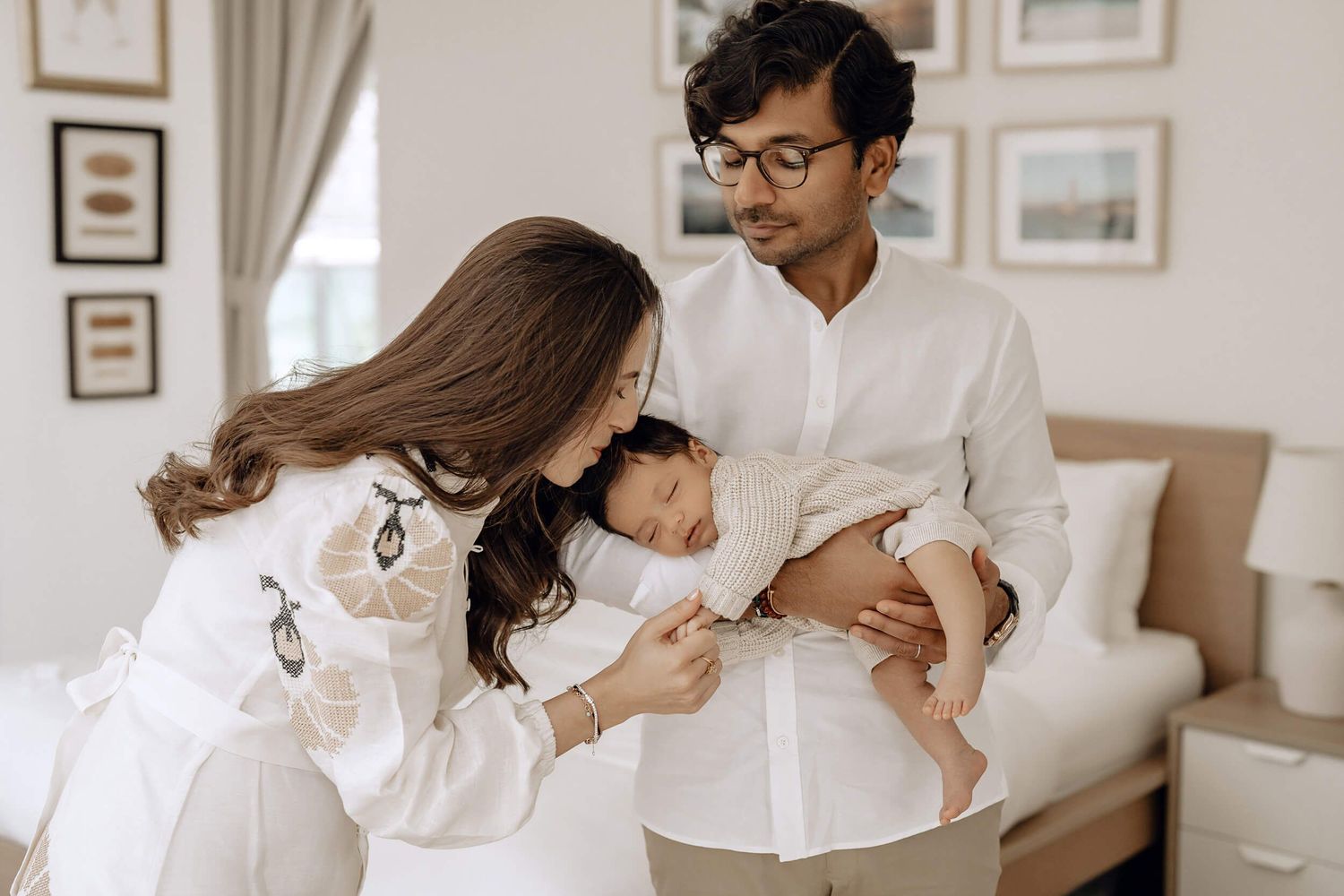 Lifestyle family photoshoot showing intimate moments in bright room with framed artwork.