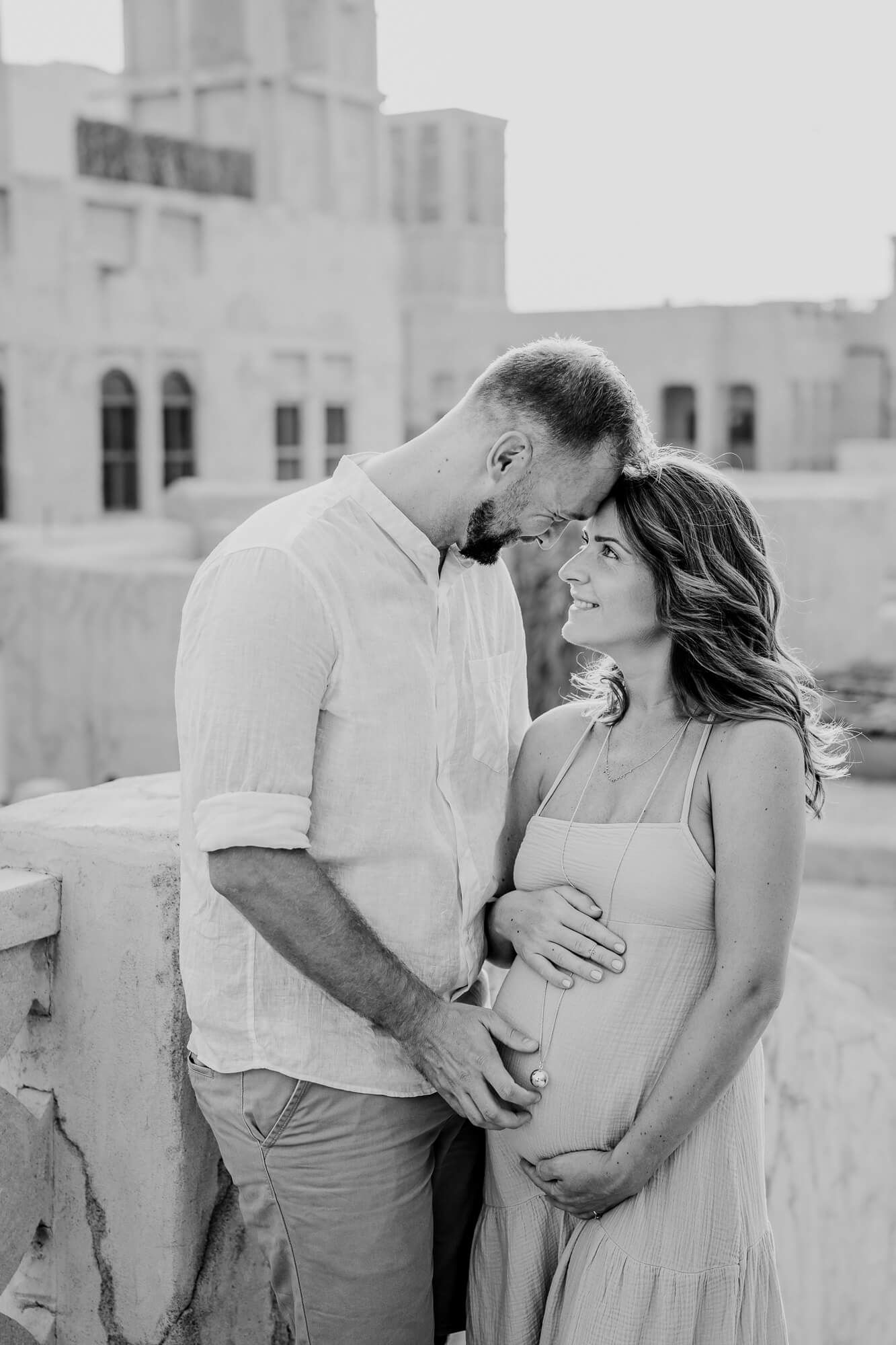 Black and white photography sequence showing a couple sharing romantic moments against a building backdrop.