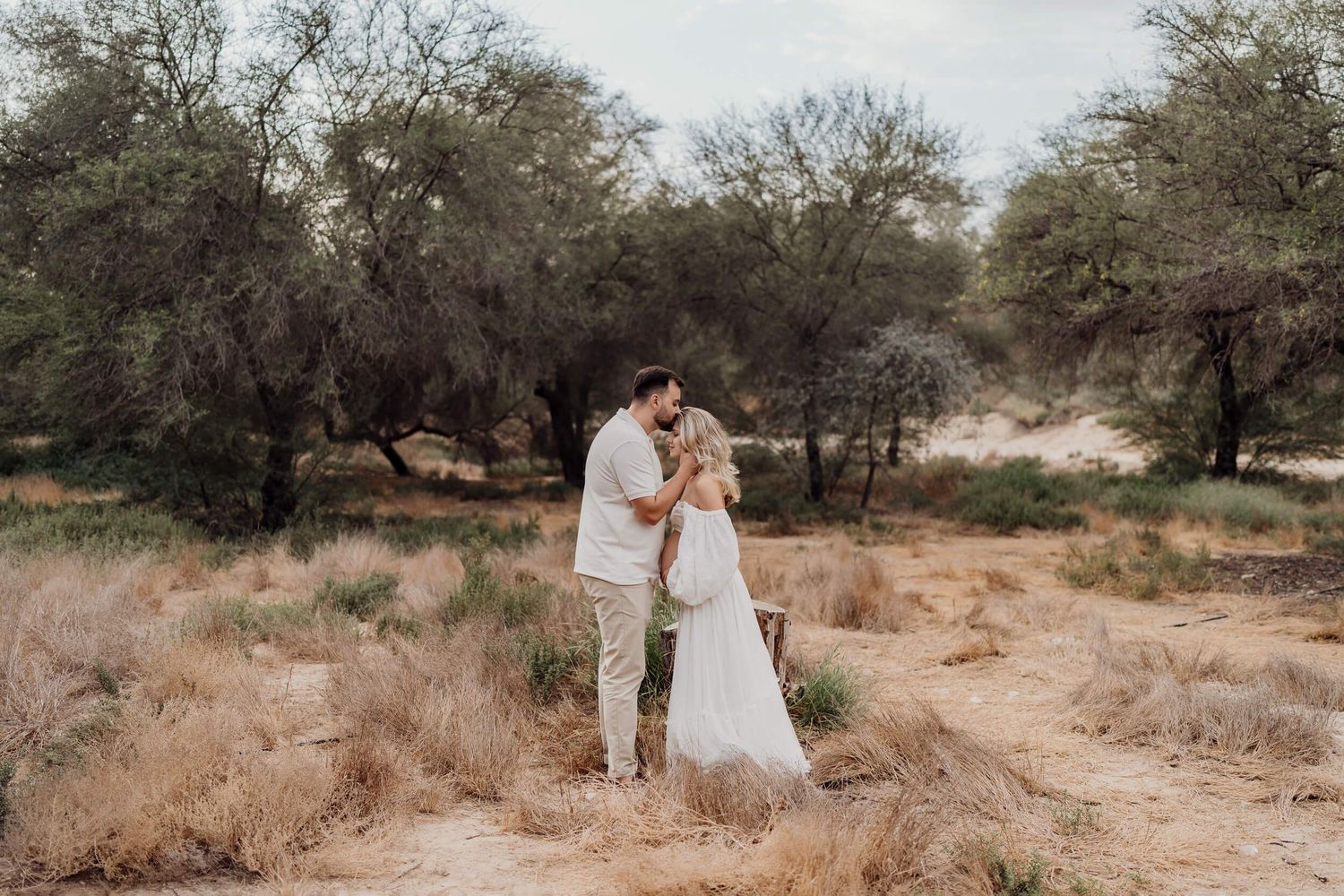 Wide landscape shots of maternity photoshoot in desert setting with natural elements.