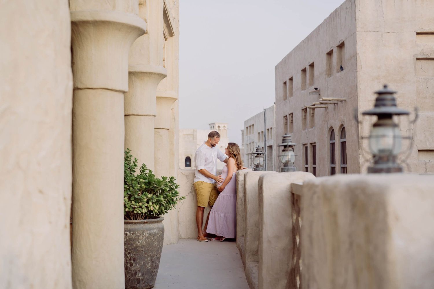 Middle eastern inspired architecture frames couple's maternity portrait in soft evening light.