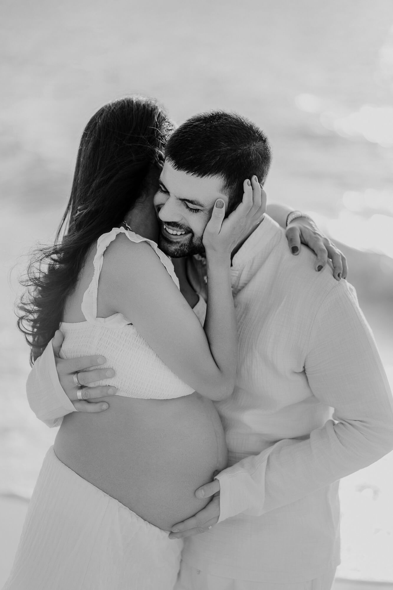 A romantic black and white sequence of intimate moments between a couple embracing on a beach.