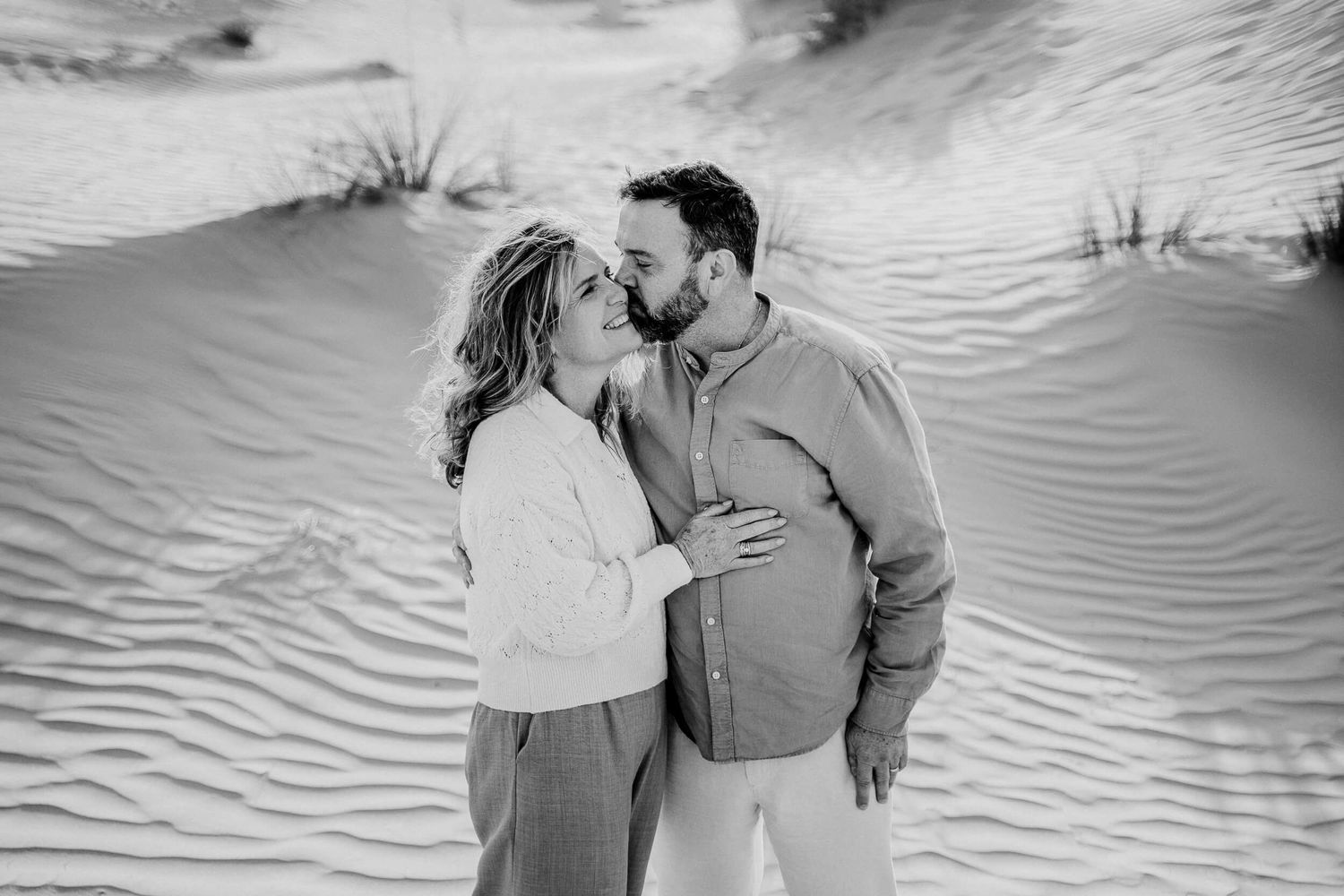 Black and white images showing romantic moments between two people in a desert landscape.