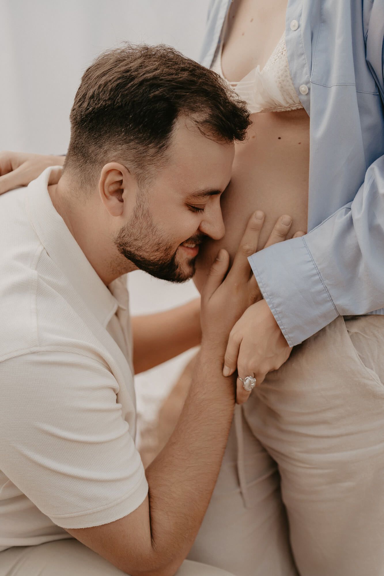 Intimate maternity moment captured in soft natural lighting.
