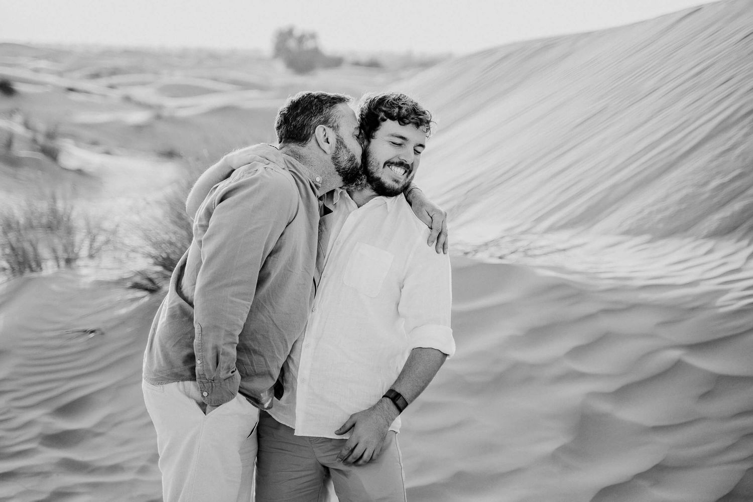 Black and white desert portrait capturing intimate moment between two people.