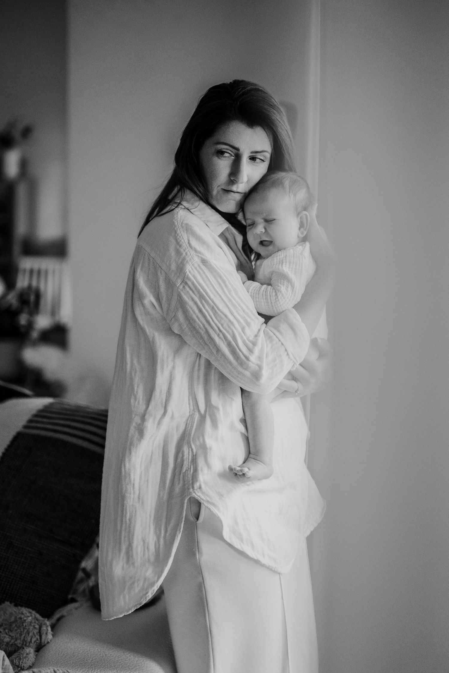 Black and white photographs show tender moments between a parent and small child in white clothing.