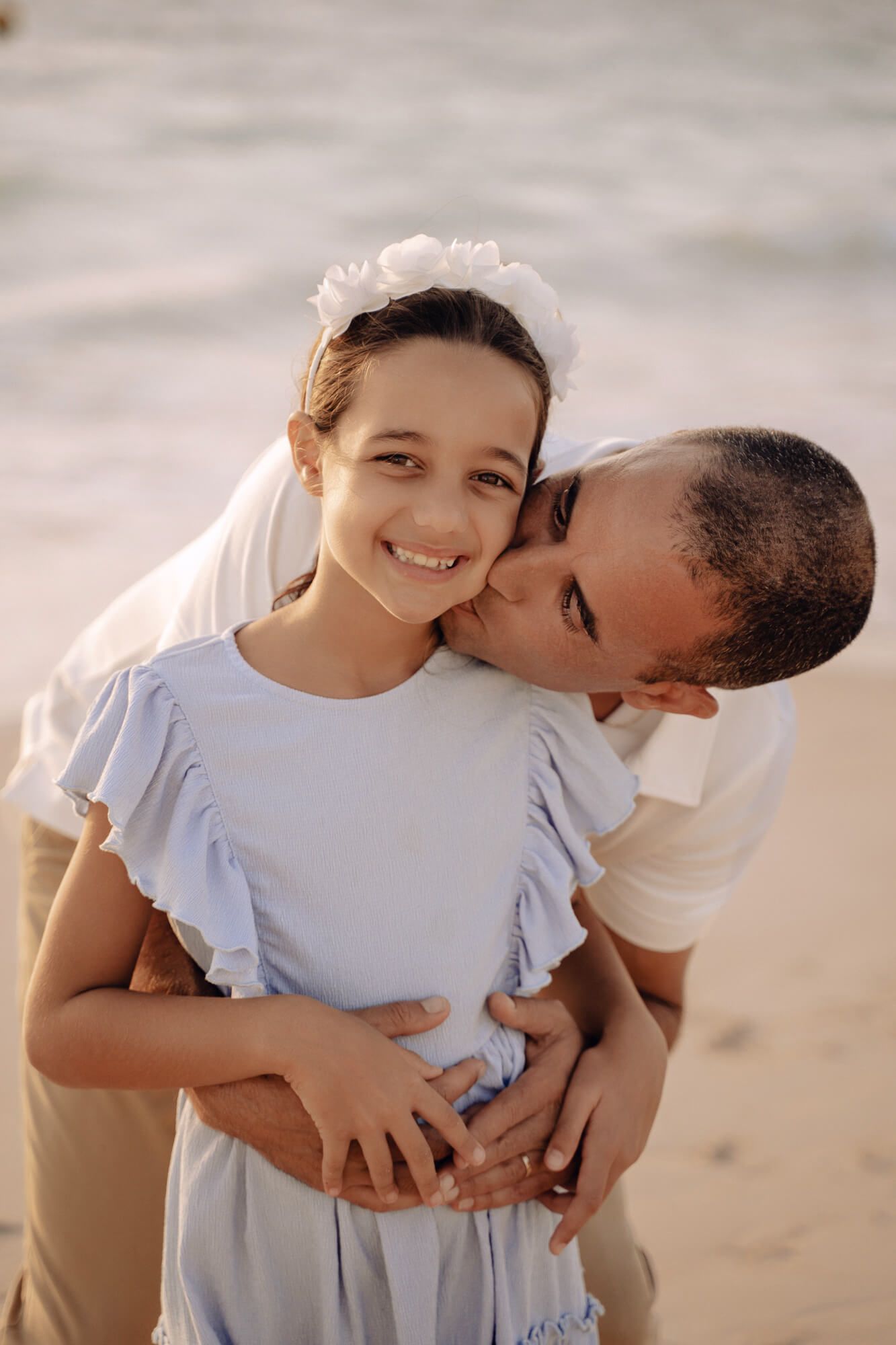 Sweet family embrace captured during sunset beach photo session.