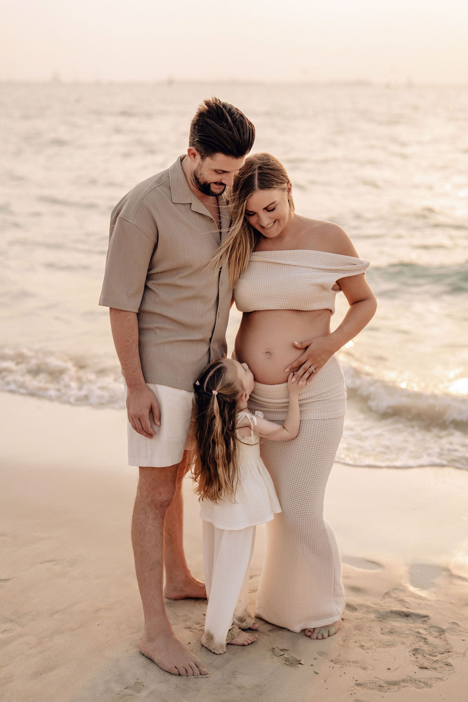 Expecting couple embracing during a beach maternity photoshoot in Dubai