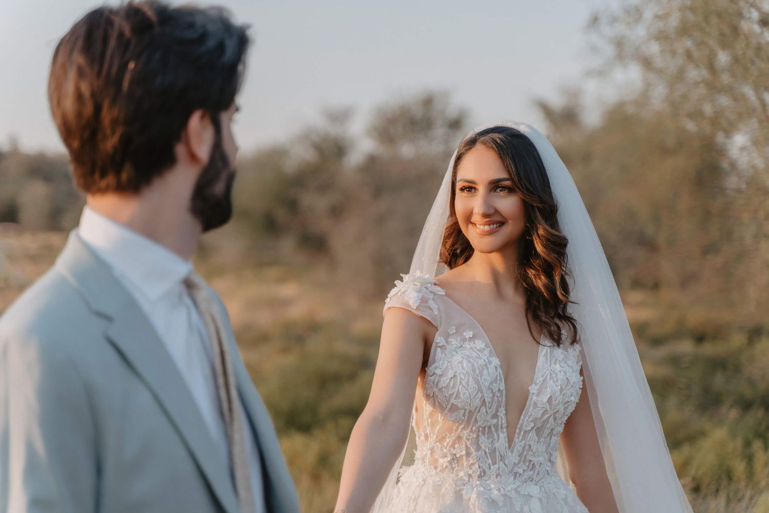 A bride and groom enjoy a tender moment together during their outdoor wedding celebration at golden hour.