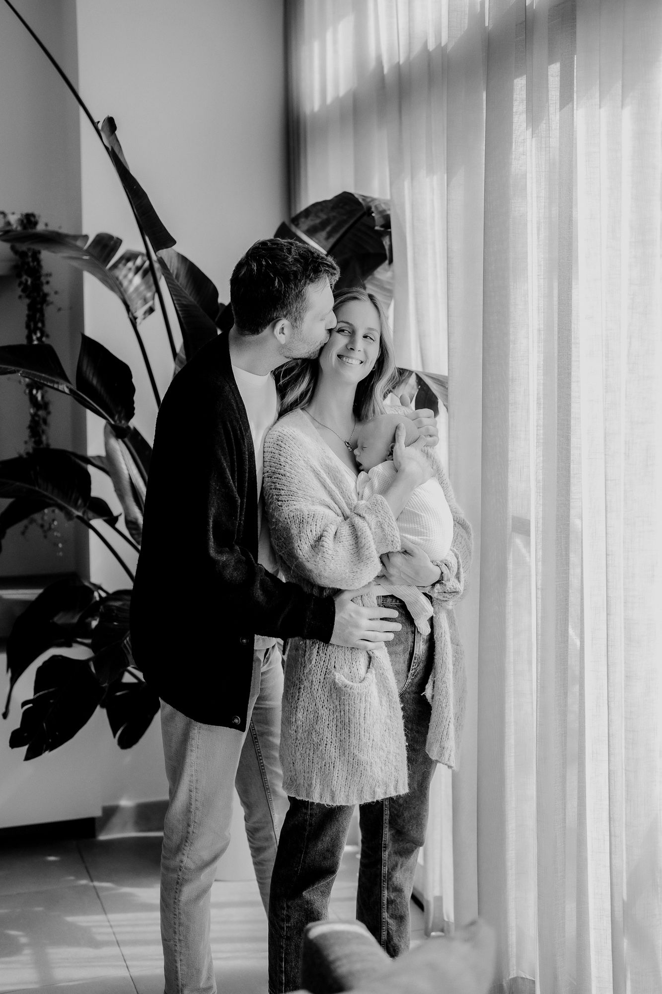 A romantic black and white photo series showing silhouettes of an embracing couple against window light.
