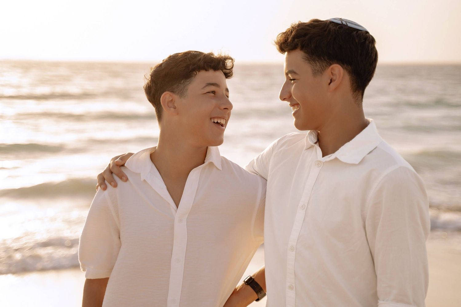 Joyful candid moments captured during sunset beach photoshoot.