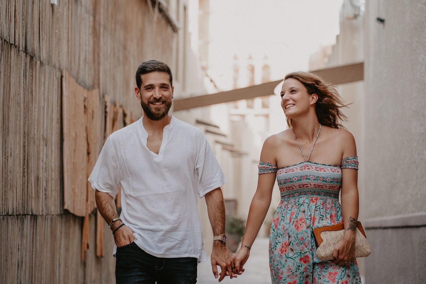 A couple walking hand in hand through al Seef in Dubai