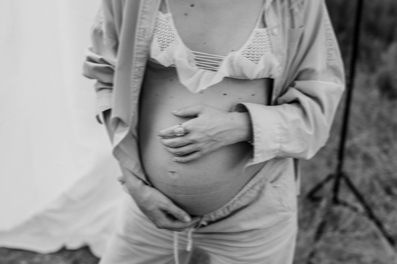 Candid black and white maternity photos showing pregnant woman's belly.