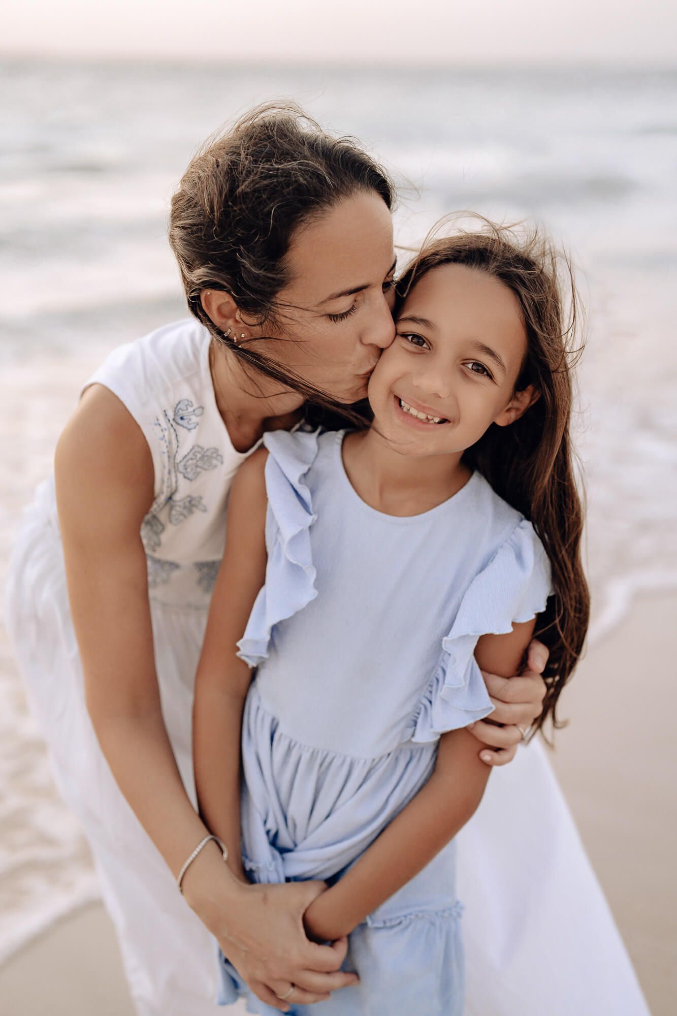 A series of tender moments captured during a casual beach photoshoot at sunset.