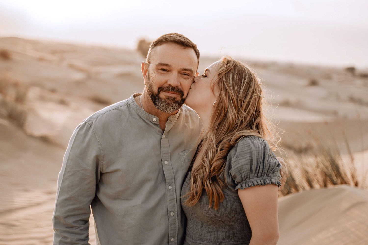 Sweet candid moment captured of a couple in the desert during golden hour.