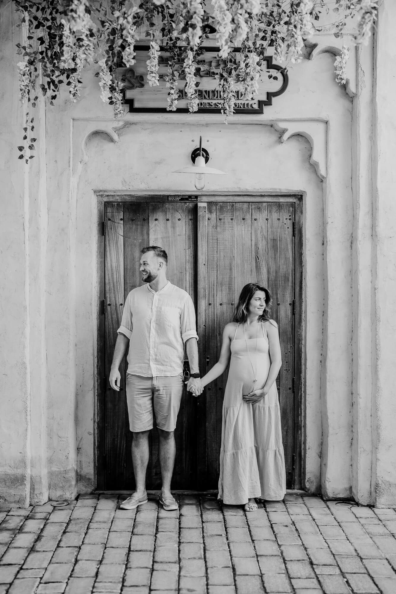 Black and white photo series showing a couple dancing together in front of a rustic door.
