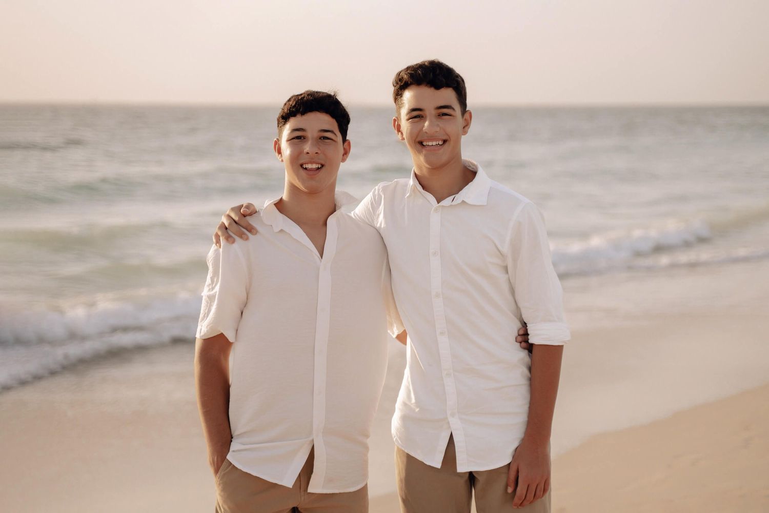Casual beachside portraits with people in white shirts laughing together.