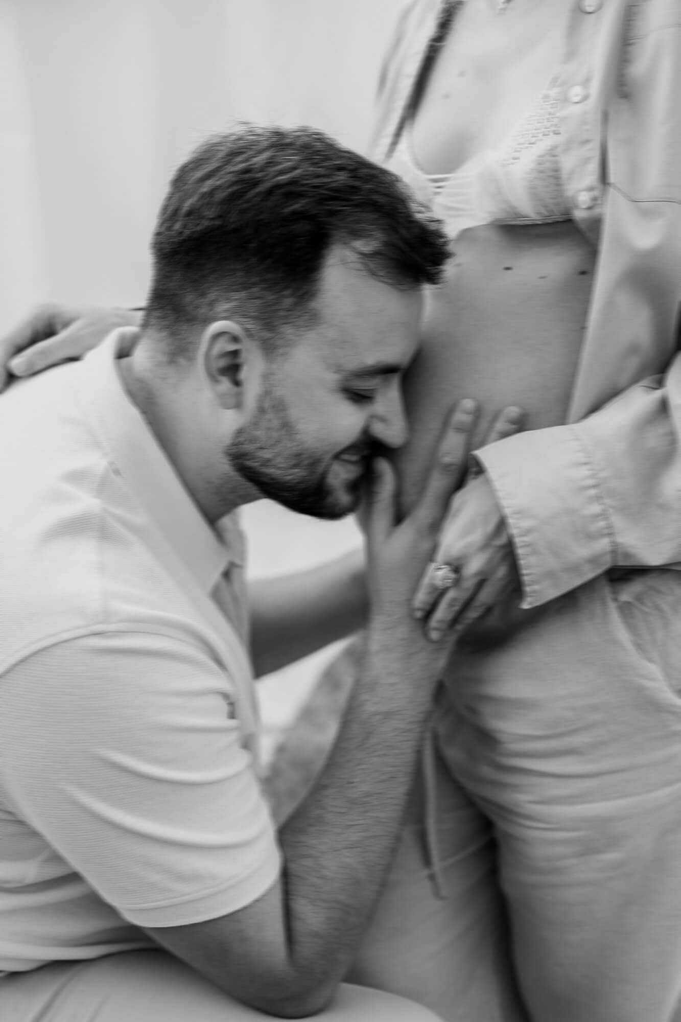 Emotional pregnancy reveal moment captured in intimate black and white photography sequence.