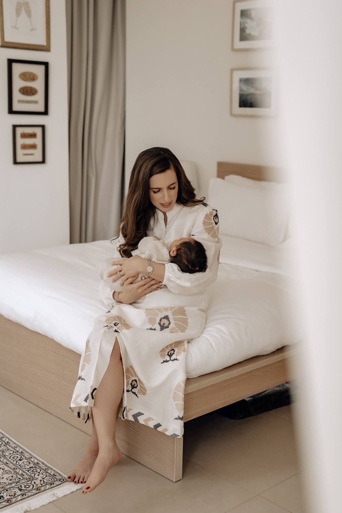 Woman in white loungewear relaxing on modern minimalist daybed.