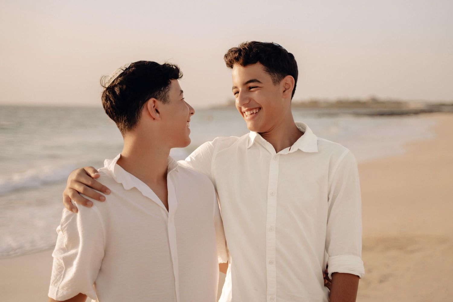 Natural light beach portraits with people sharing candid laughing moments.