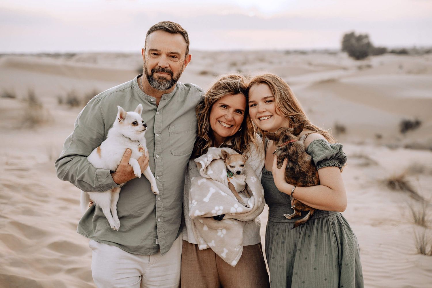 Sweet family photos taken in a desert landscape with adorable dogs and matching outfits.