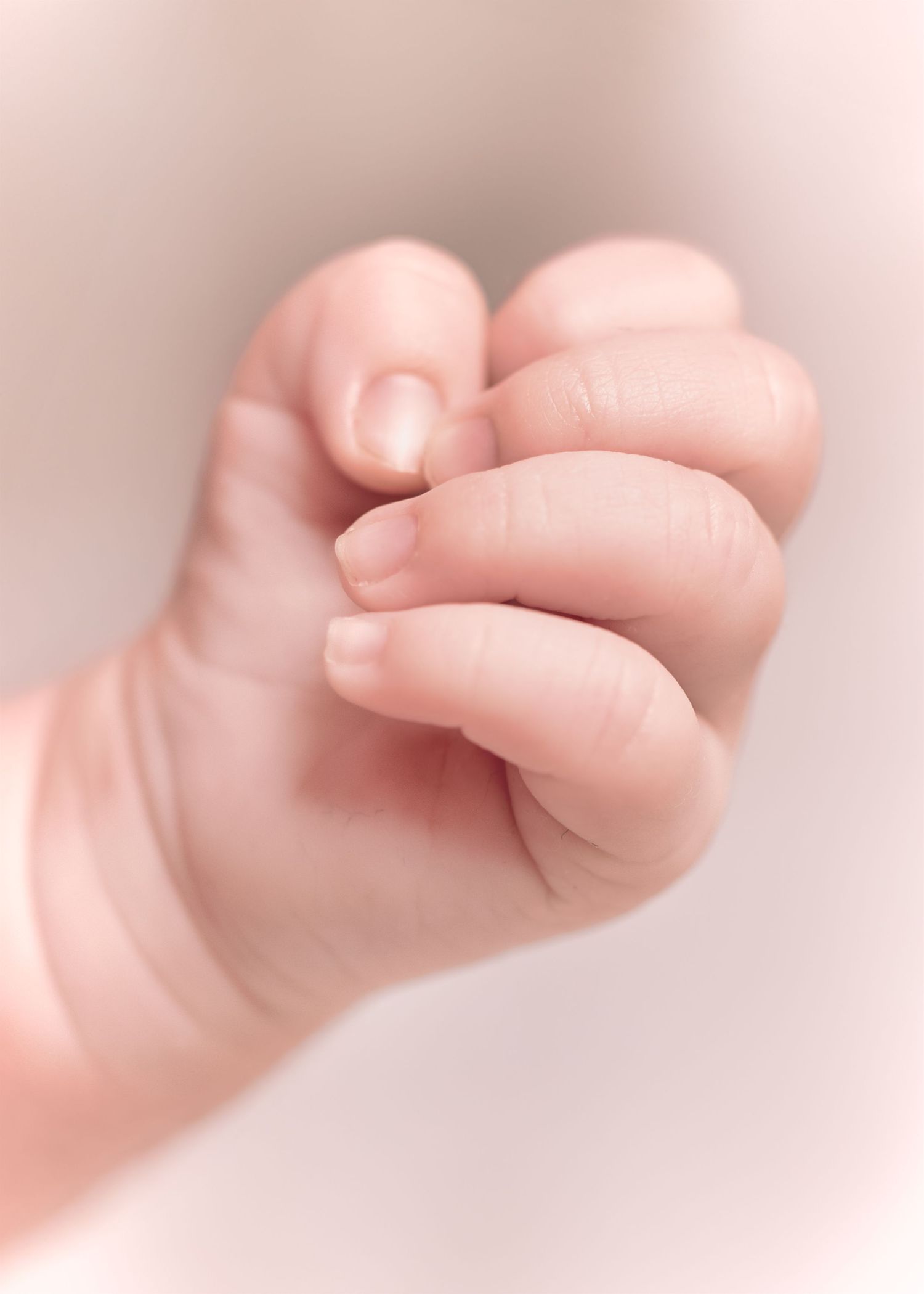 Main de nouveau-né serrant le doigt de sa maman, détail poétique, photographie naissance dans le Ternois – Paul-Victor Photographies.
