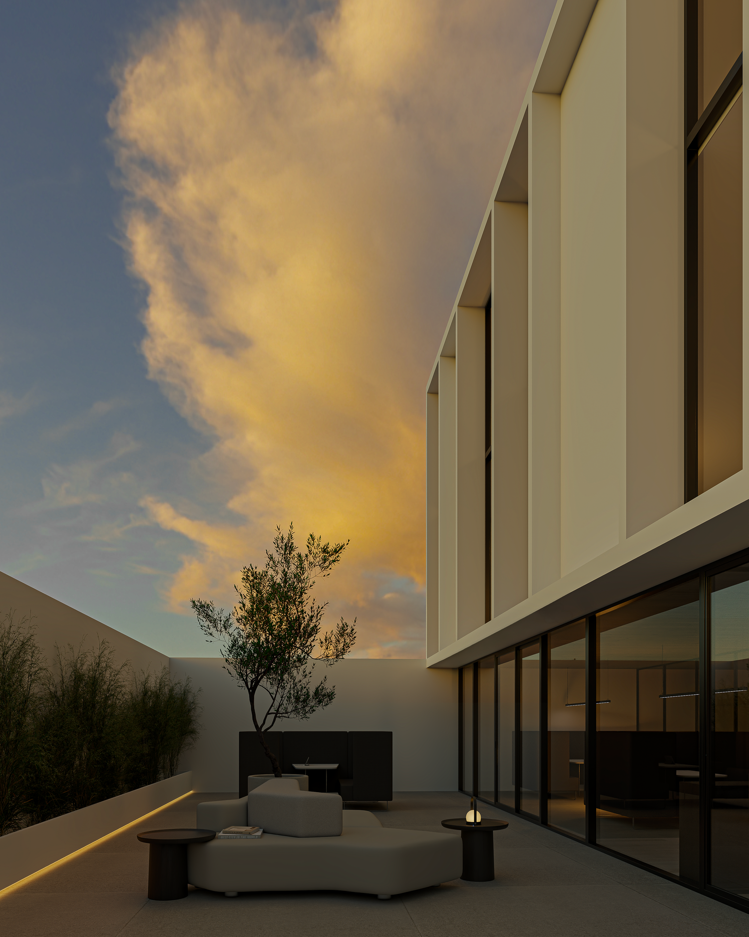 Modern courtyard patio with outdoor sofa at dusk, featuring dramatic golden clouds and sleek architectural facade.